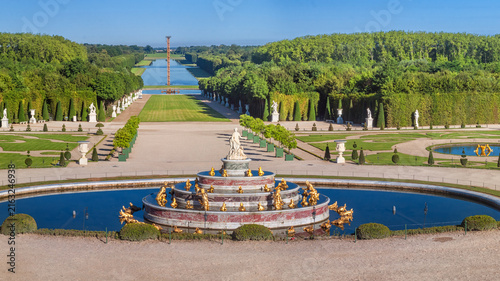 View of the Versailles Park - the Latona Basin with the Grand Canal in the background under the summer sun, Versailles, France