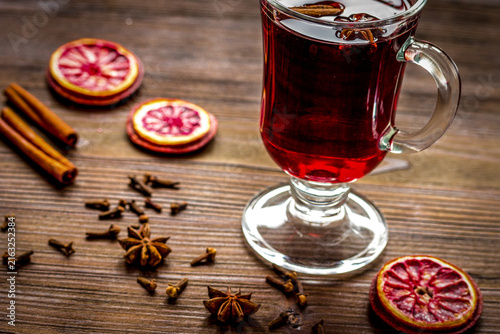 Fotografie mulled wine with spices in cup on wooden background