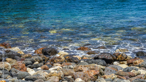 Принти на полотні Crystal clear turquoise Pacific water washing over a colorful beach of smooth vo