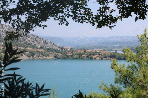 Scenic Mountain Lake Landscape Framed by Tree Leaves for Outdoor Recreation Hiking and Camping