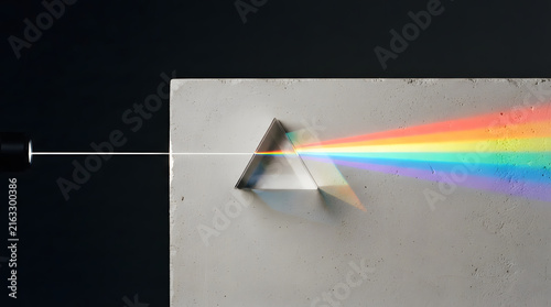 Prism refracting white light into vibrant rainbow spectrum on dark surface
