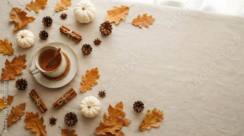 Autumn coffee break with latte, chocolate cookies, and maple leaves on cozy linen backdrop