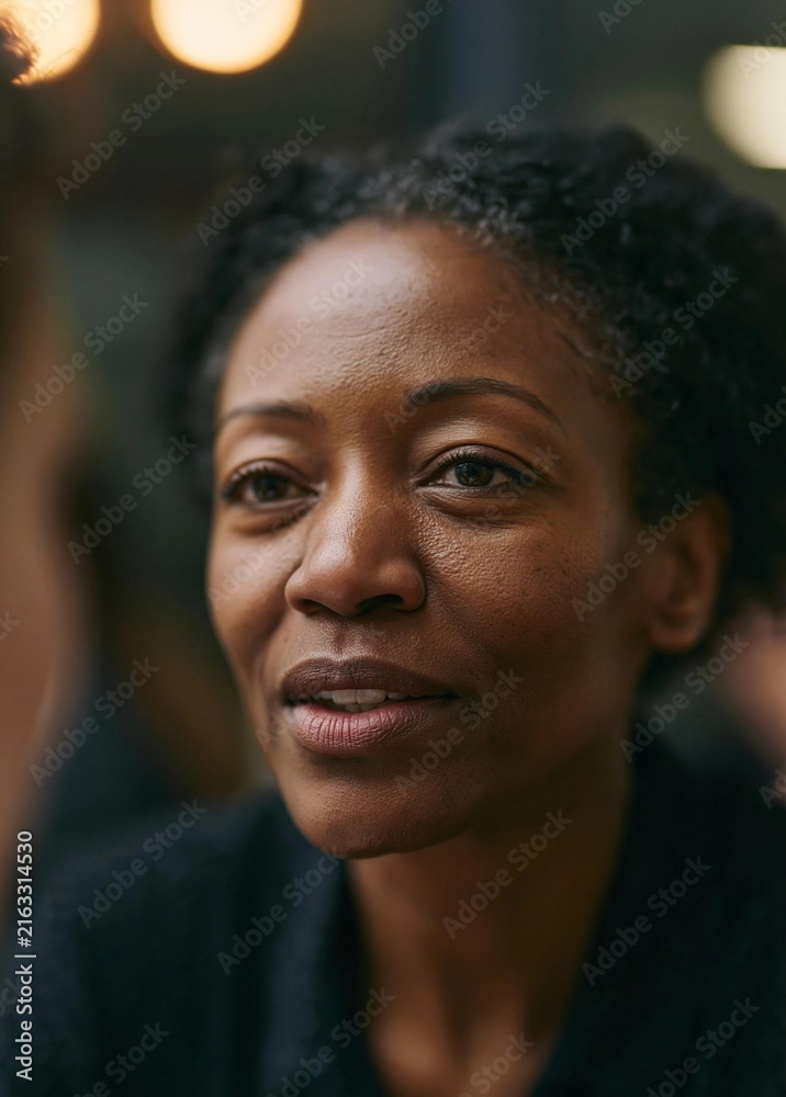 Obraz premium Close-up portrait of a middle-aged african-american woman. she appears to be in her late 40s or early 50s, with short, curly hair.