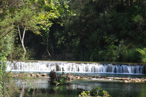 Horizontal River Cascade Waterfall Surrounded by Dense Forest for Hiking and Outdoor Tourism