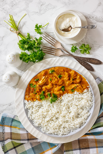 Butter chicken with fluffy basmati rice on plate