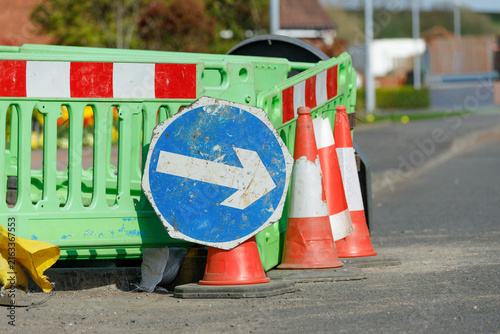 Keep right sign with traffic cones and green barrier close up detail