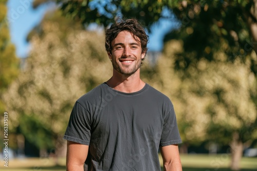 Sunny outdoor portrait of a smiling young man in casual wear