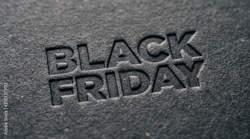 Embossed Black Friday text on textured dark gray background close up macro shot