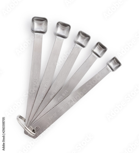 Five stainless steel measuring spoons of different sizes isolated on a white