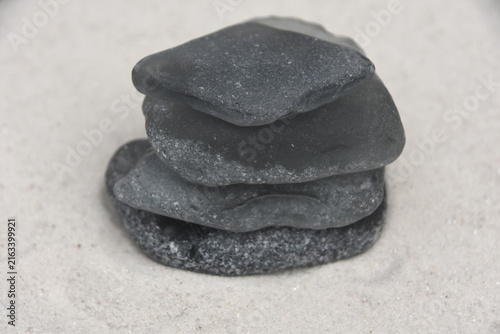 Stacked Grey Sea Glass on a White Sand Beach