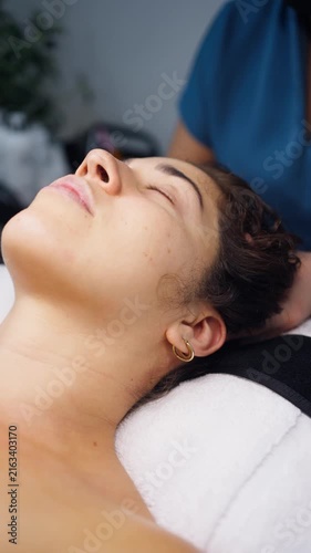 Cosmetologist performing facial cleansing and head massage