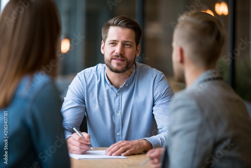 Recruiter Takes Notes While Listening to a Potential Employee During an Interview in a Modern Office Setting