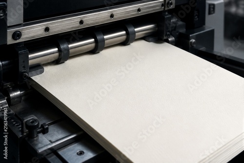 Paper stack feeding into industrial printing press machine