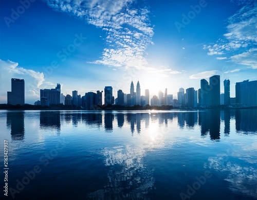 blue city skyline silhouette with reflection on water