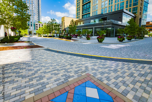 Spacious Reston plaza features patterned paving, outdoor furniture, and modern architecture.