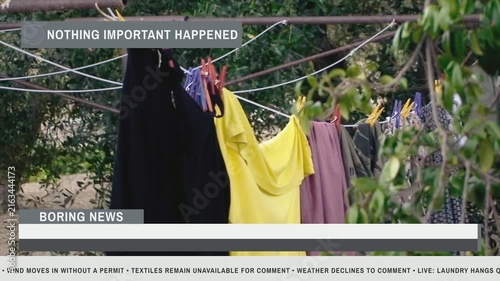 Colorful laundry drying on clothesline in rural countryside with parody news overlay. Features mundane outdoor chore scene for satirical editorial themes.
