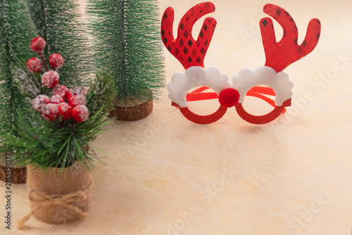 Reindeer glasses and artificial christmas trees with red berries arranging a festive still life, symbolizing the joy and cheer of the holiday season and winter celebrations
