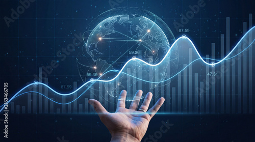Hand holding glowing earth hologram with financial graph data overlay in dark digital background