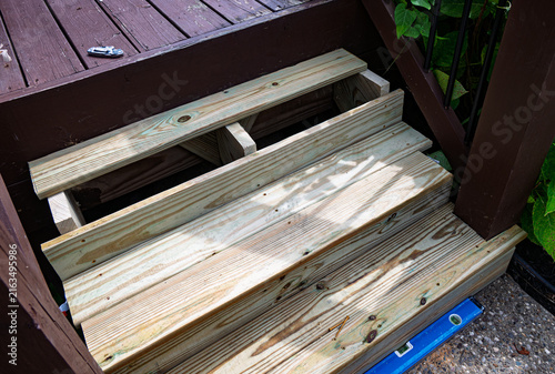 Wooden stair replacement under construction lead to dark brown deck.