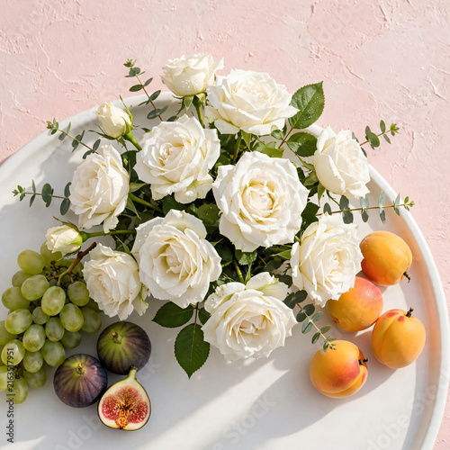 White roses and fresh summer fruits on white tray