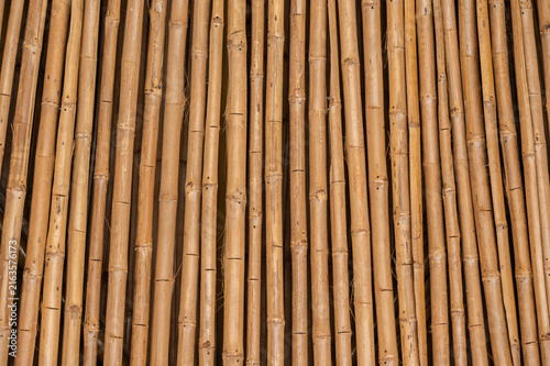 Full frame shot of brown bamboo arranged as fence. A bamboo fence is an eco-friendly, natural boundary made from bamboo poles or slats.