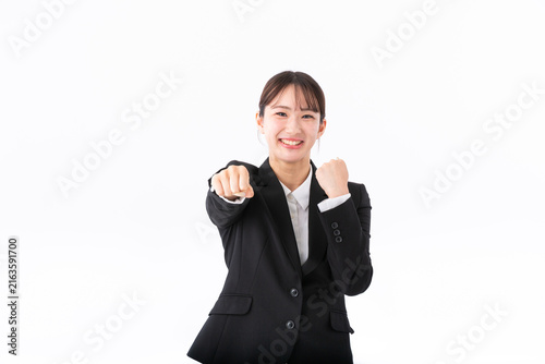 ガッツポーズをするスーツの若い女性
