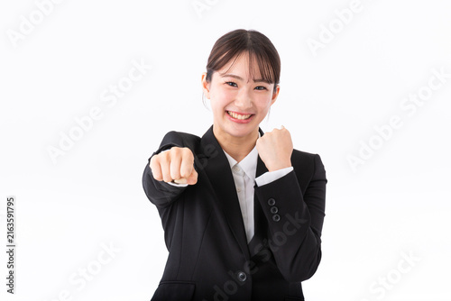 ガッツポーズをするスーツの若い女性