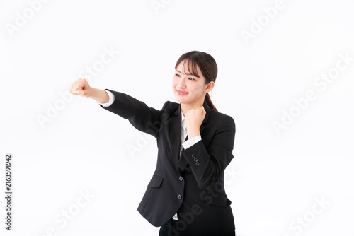 パンチをするスーツの若い女性