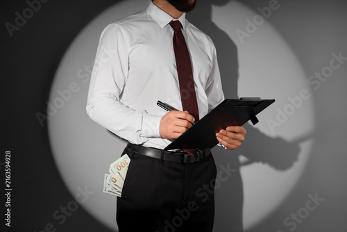 Obraz na plátně Corruption and bribery in business, man with money in pocket holding clipboard a