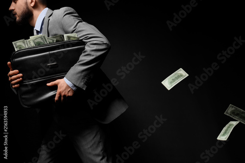 Photography Financial crime and corruption, businessman running with a briefcase full of mon