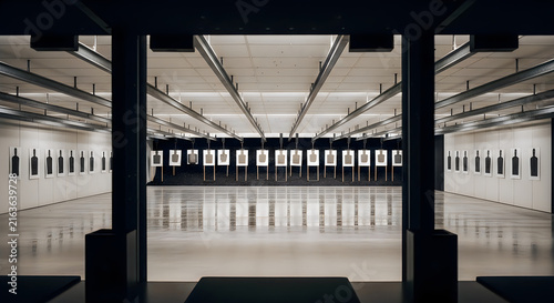 Indoor shooting range with rows of target paper silhouettes in brightly lit facility.