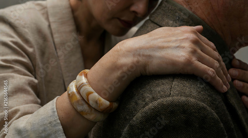 Intimate embrace showing emotional support with a snake coiled around the woman's wrist
