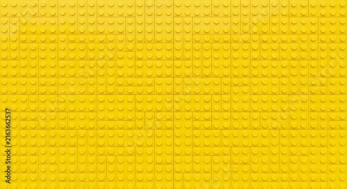 Bright yellow textured wall with vertical and horizontal seams for modern interior design backdrop