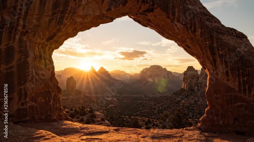 Natural Stone Rock Arch Framing Scenic Desert Mountain View at Golden Sunrise