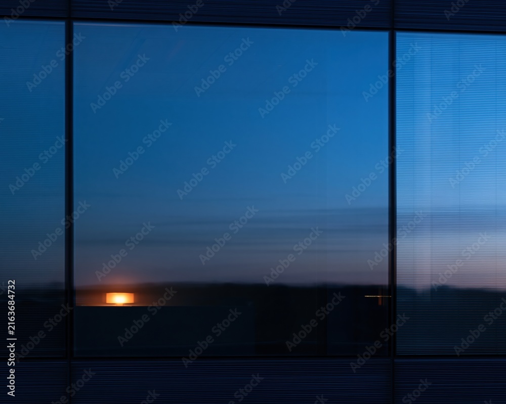 Fototapeta premium Dark glass curtain wall with a soft navy blue sheen and a warm golden light reflection, creating a quiet corporate background for overlays
