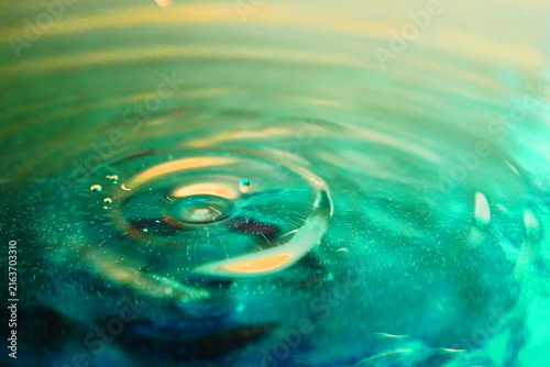 Concentric Water Ripples on Green and Gold Liquid Surface Close Up