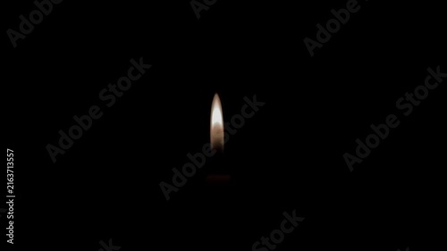 A lone candle flame flickering gently against a completely dark backdrop.