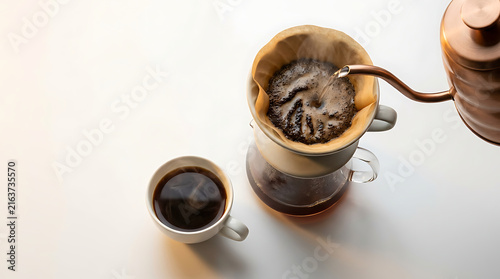 Copper Kettle Pouring Hot Water Over Fresh Coffee Grounds in a Pour Over Dripper to Brew Delicious Coffee in a White Ceramic Mug