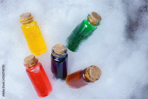 Fotografie Small glass bottles with cork stoppers containing vibrant liquid potions, nestle