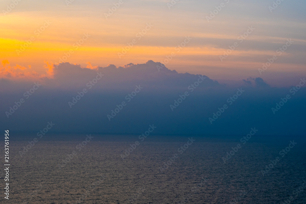 Fototapeta premium nature sky breathtaking golden sunset over a calm ocean, with the entire sky and water bathed in brilliant shades of yellow and orange. Streaky clouds enhance the dramatic display 