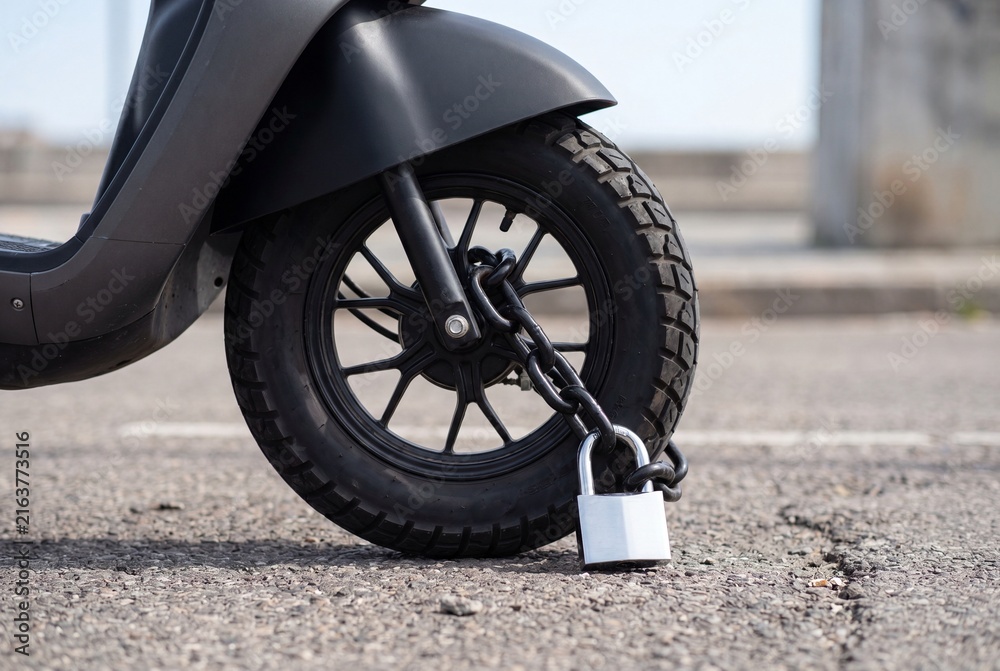 Fototapeta premium Robust Chain and Padlock Securing Scooter Wheel