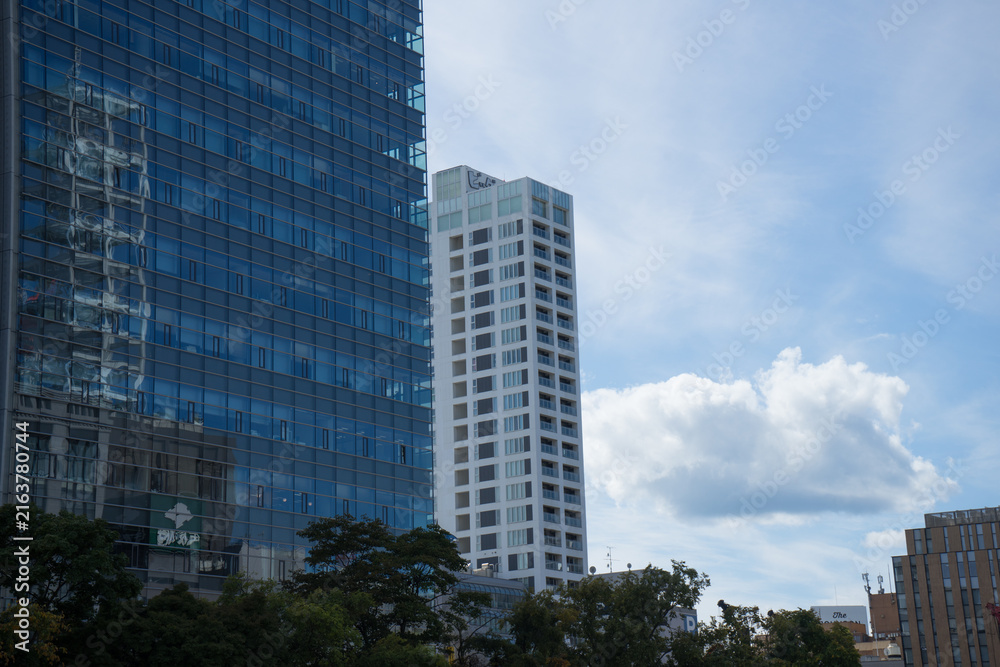 Fototapeta premium 都会の大きなビルと壁面に映る風景