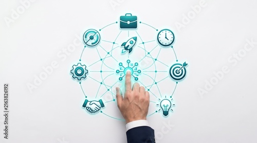 Male hand touching central virtual button surrounded by business strategy icons like rocket, target, gear, and lightbulb, representing innovation and startup growth