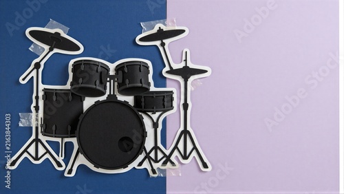 Black drum set cutout on blue and purple background.