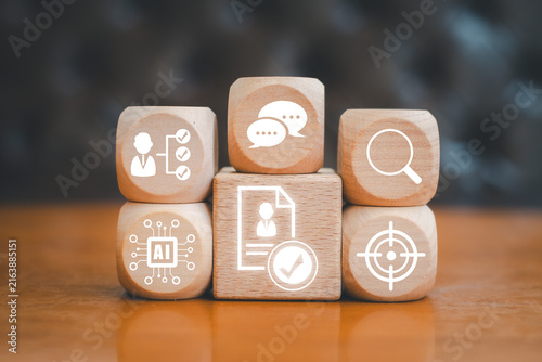 Visual representation of AI-driven talent acquisition using digital icons on wooden blocks, symbolizing modern recruitment strategies.