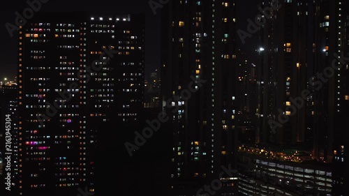 An aerial view of Mumbai's high-rise buildings and beautiful nightlights. The sky is cloudy, and there is medium traffic on the road. The cityscape is filled with modern illuminated buildings.