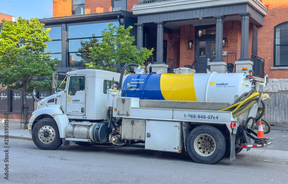 Fototapeta premium Ottawa, ON, Canada. Aug 19, 2026. Side profile of a Walker Grease Trap Services tank truck parked on an urban street in front of a building.