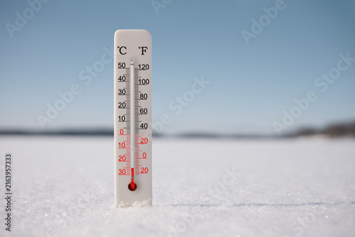 Celsius and fahrenheit scale thermometer in snow. Ambient temperature minus 25 degrees celsius