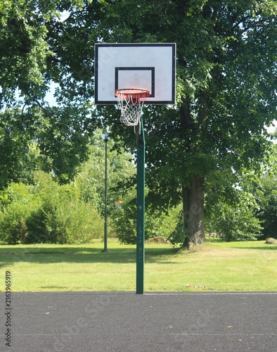 Outdoor Public Park Basketball Hoop with Green Pole and White Backboard.

