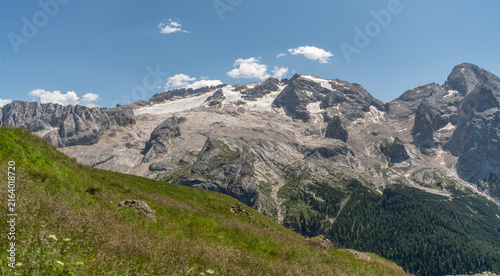 Arabba, Italy. Marmolada glacier and rugged Dolomite mountain massif above alpine meadows